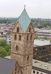 Die Turmspitze der Marienkirche in Dortmund hat eine quadratische Grundfläche ABCD, auf der vier senkrecht gemauerte gleichseitige Dreiecke stehen; die vierteiligen Dachflächen der Turmspitze sind rautenförmig. (Abitur-Musteraufgabe Mustersatz M02 Wahlteil Analytische Geometrie ab 2019 Aufgabe B1 Grafik 1/© by www.fit-in-mathe-online.de)